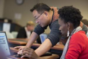 Dr. Hsin-Te Yeh working with a student of African-American descent at a computer.