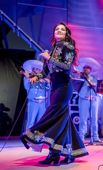Lupita Infante在粉色和紫色的舞台上表演