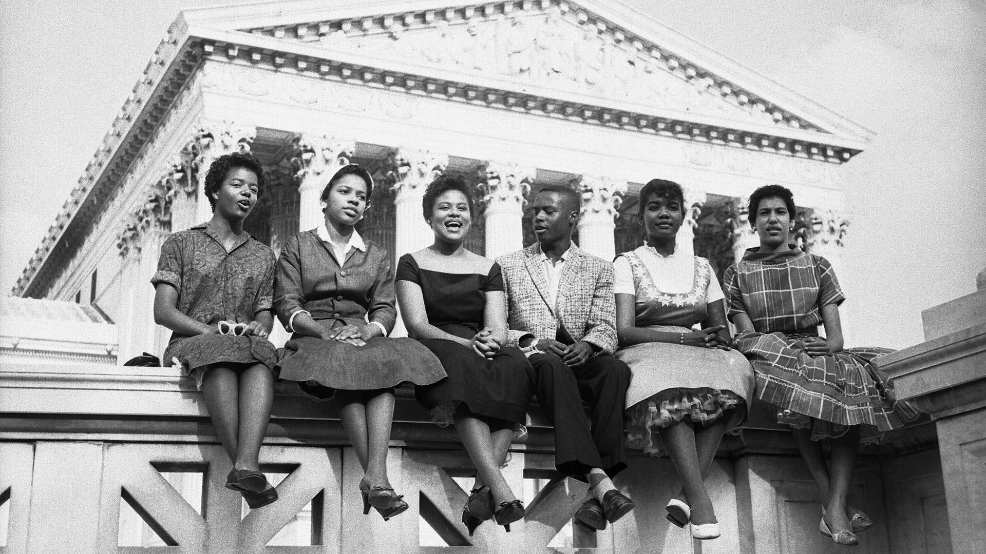 Six Black children who attended Little Rock's Central High School sit outside the Supreme Court in this 1958 photo. 从左到右:卡洛塔墙, 15, Melva Patillo, 16, 托马斯杰佛逊, 15, 米妮·简·布朗, 16, Gloria Ray, 15, 伊丽莎白·埃德克福德, 16. 图片来源:Getty Images