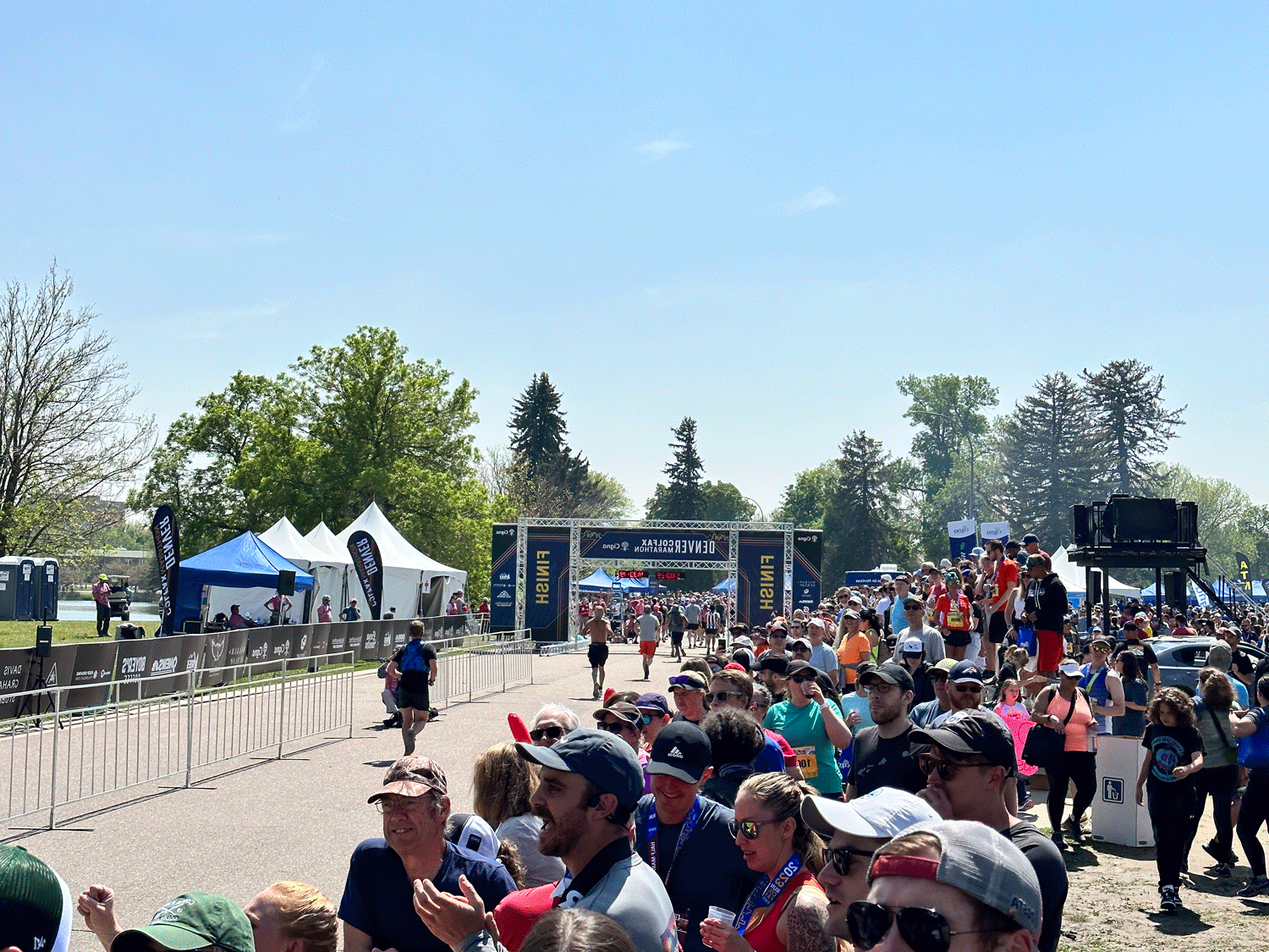 Runners crossing the finish line in front of a large crowd at the 2023 丹佛 Colfax Marathon