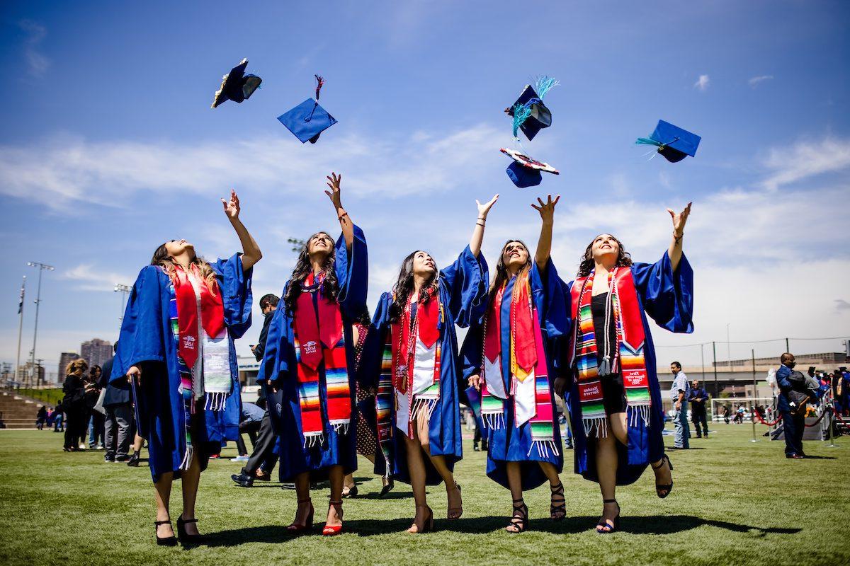 5名密歇根州立大学毕业生将帽子抛向空中的照片